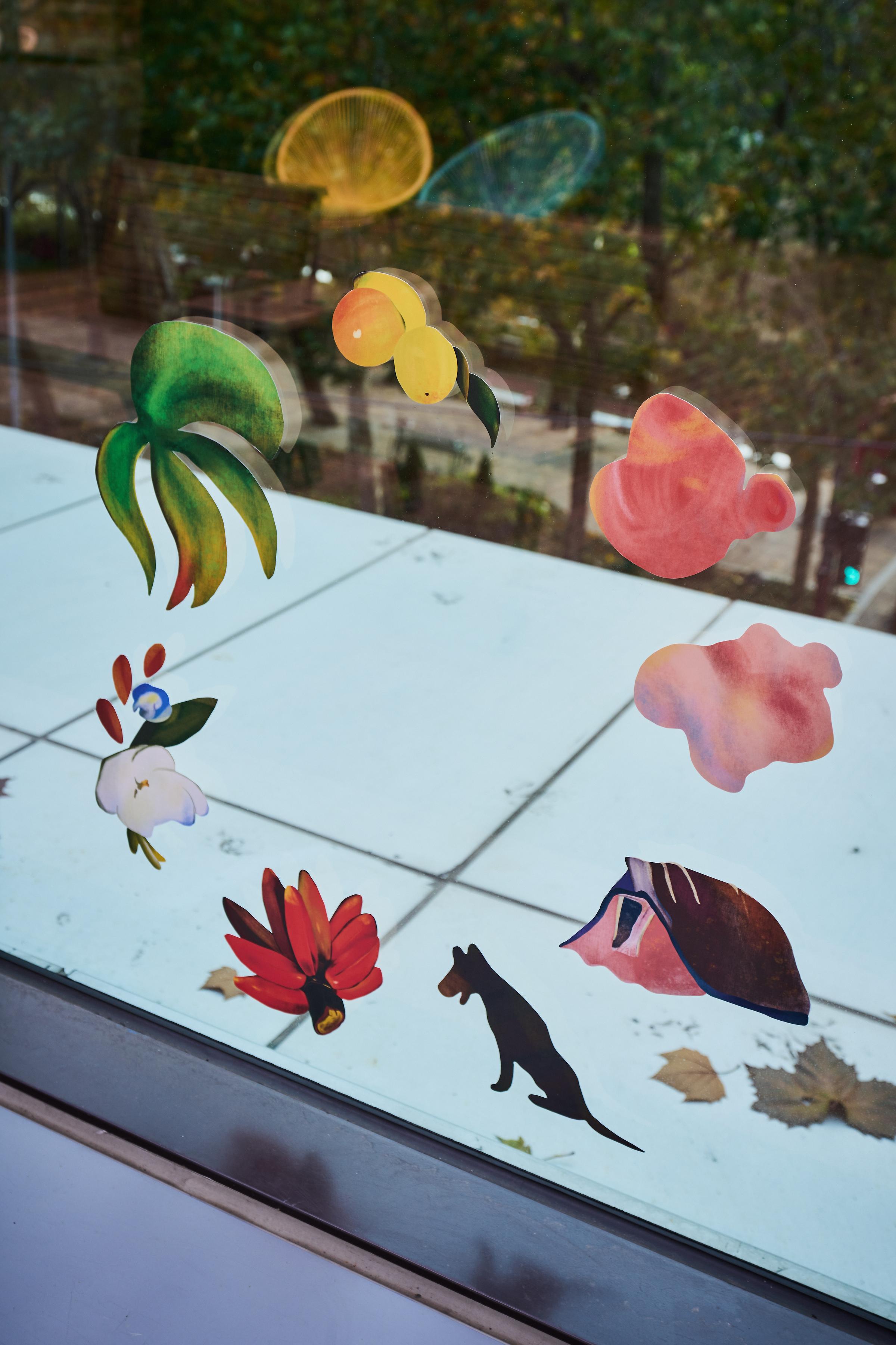투명 창에 꽃과 열매, 나뭇잎 등의 스티커가 둥글게 붙어있는 사진