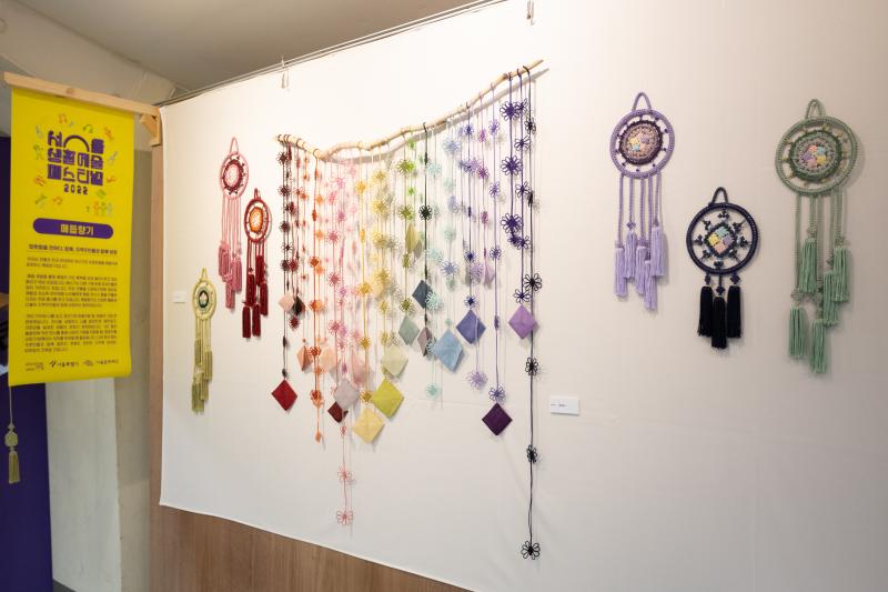 드림캐쳐 등의 매듭 공예품들이 벽에 걸려 전시되어있는 사진